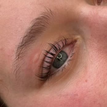 Cils recourbés avec effet volume naturel sur femme aux yeux gris-bleu, finition soignée à Dijon.